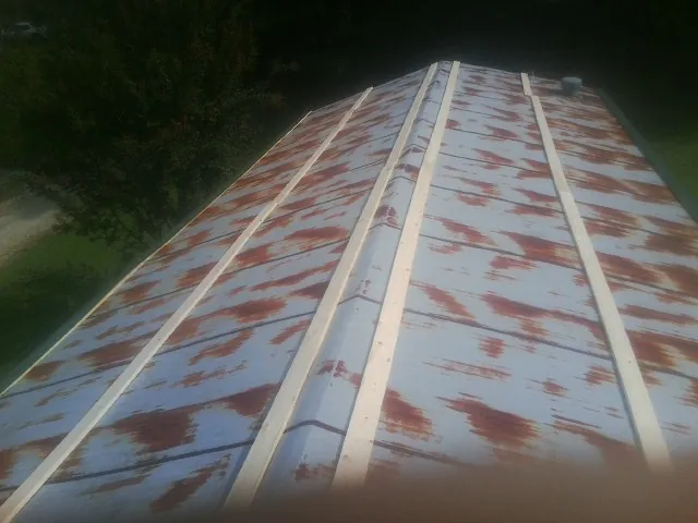 Rusted metal roof panels with new wood purlins before replacement — Storm Damage Roof Repair in Dexter by Roofing Brothers